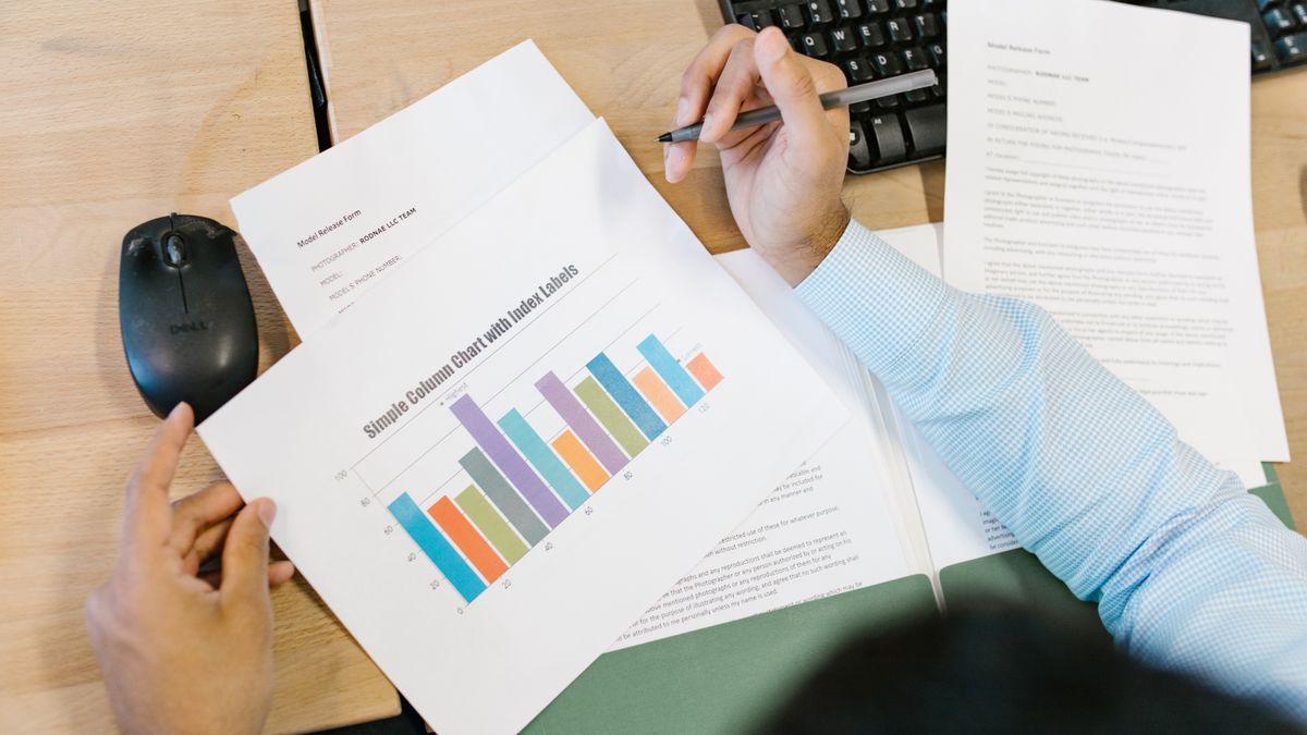 A financial analyst reviewing performance charts on a monitor at a desk
