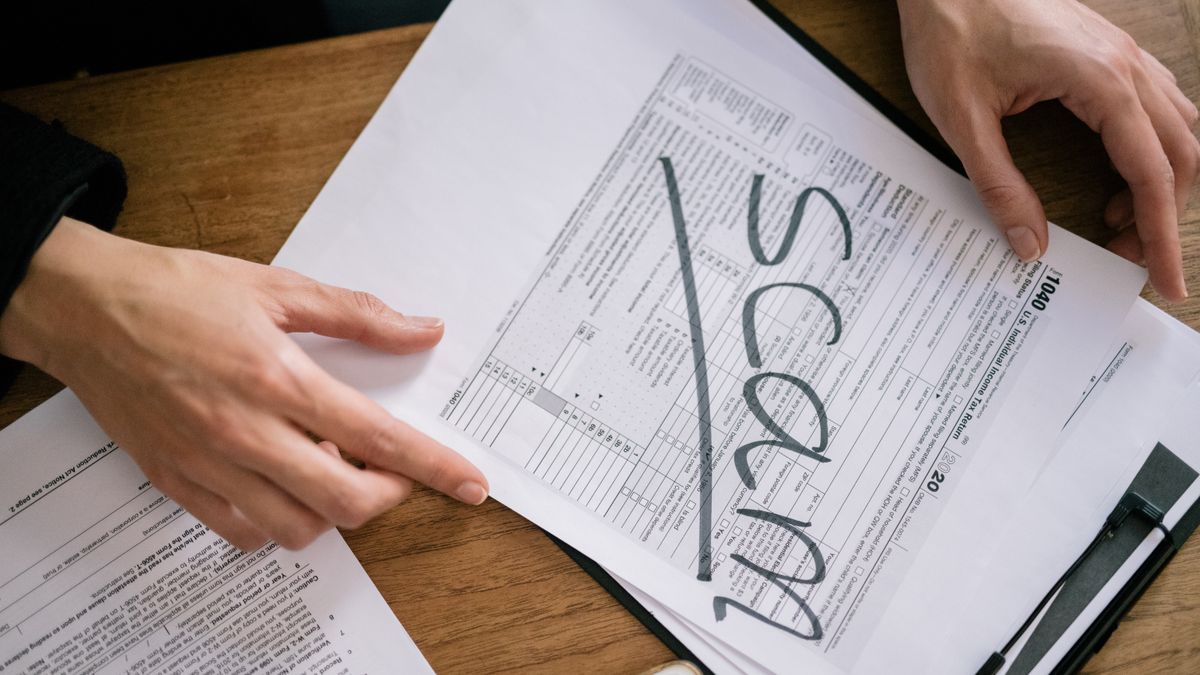 Regulatory and compliance documents arranged on an office desk with a pen