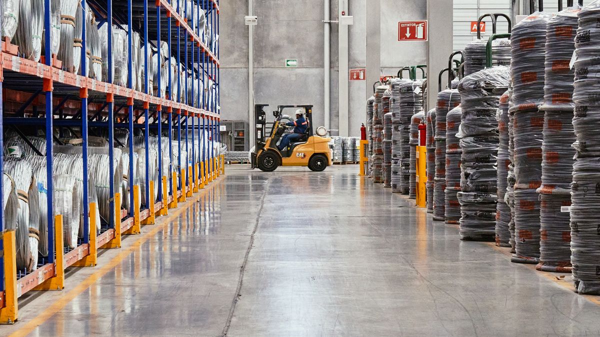 Workers reviewing operations on the floor of an industrial warehouse
