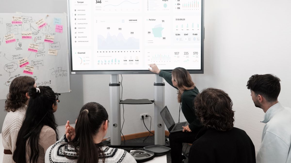 A team reviewing live dashboards on a large screen during a working session